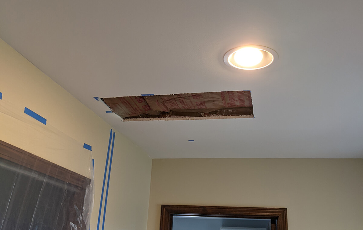 Photo of a hole in the ceiling drywall.