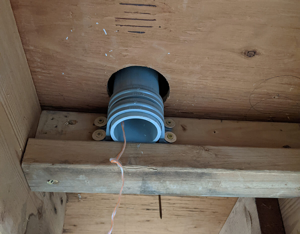 PVC pipe secured to the basement floor joists